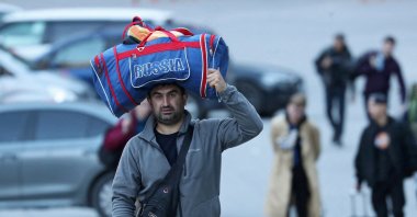A man carries a bag on his head as he travels from Russia across the border to Georgia at the Zemo Larsi/Verkhny Lars station, Georgia, Sept. 26, 2022. (Reuters Photo)