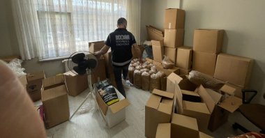 A police officer checks seized illicit tobacco in an apartment in Istanbul, Türkiye, Nov. 1, 2022. (İHA Photo)