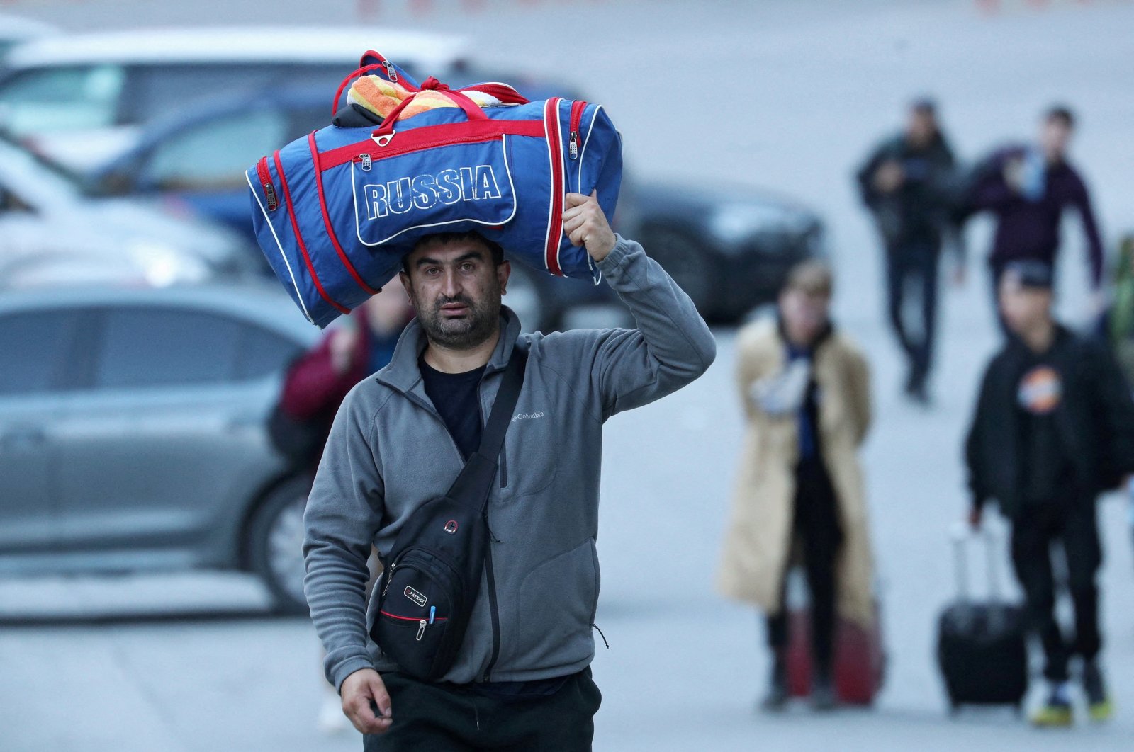 A man carries a bag on his head as he travels from Russia across the border to Georgia at the Zemo Larsi/Verkhny Lars station, Georgia, Sept. 26, 2022. (Reuters Photo)