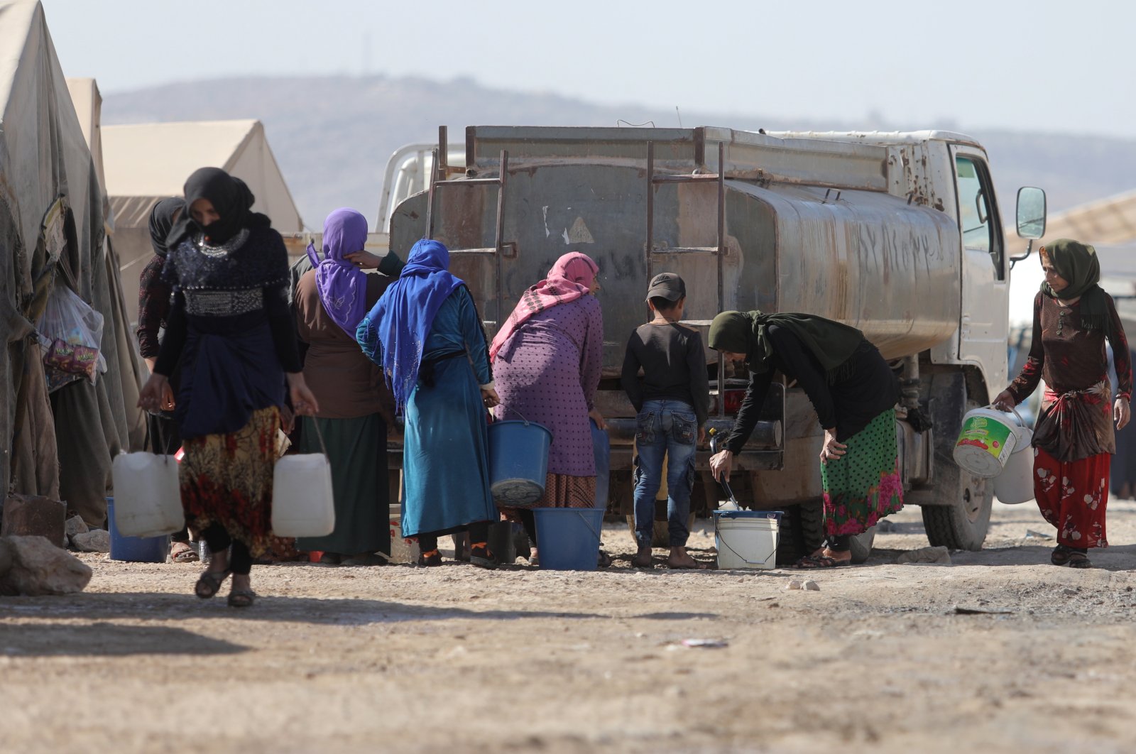 Syrian refugees fill water from a tank at Kalbeet camp, north Idlib, Oct. 29, 2022. (EPA Photo)