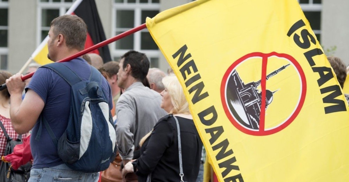 A supporter of a right-wing organization holds a flag reading:  &quot;Islam, No Thanks,&quot; during a rally, Erfurt, Germany, June 4, 2016. (File Photo)