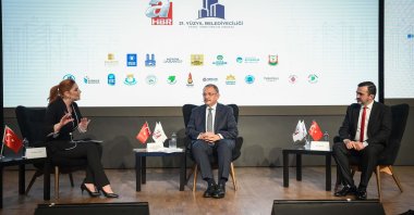 (L-R) A Haber Presenter Merve Türkay, Türkiye’s ruling Justice and Development Party (AK Party) Chairperson of Local Administrations Mehmet Özhaseki, and A News Editor-in-Chief Orhan Sali at the “21st Century Municipalism: Local Administrations Summit” held in Istanbul, Türkiye, Nov. 7, 2022. (Courtesy of A Haber)