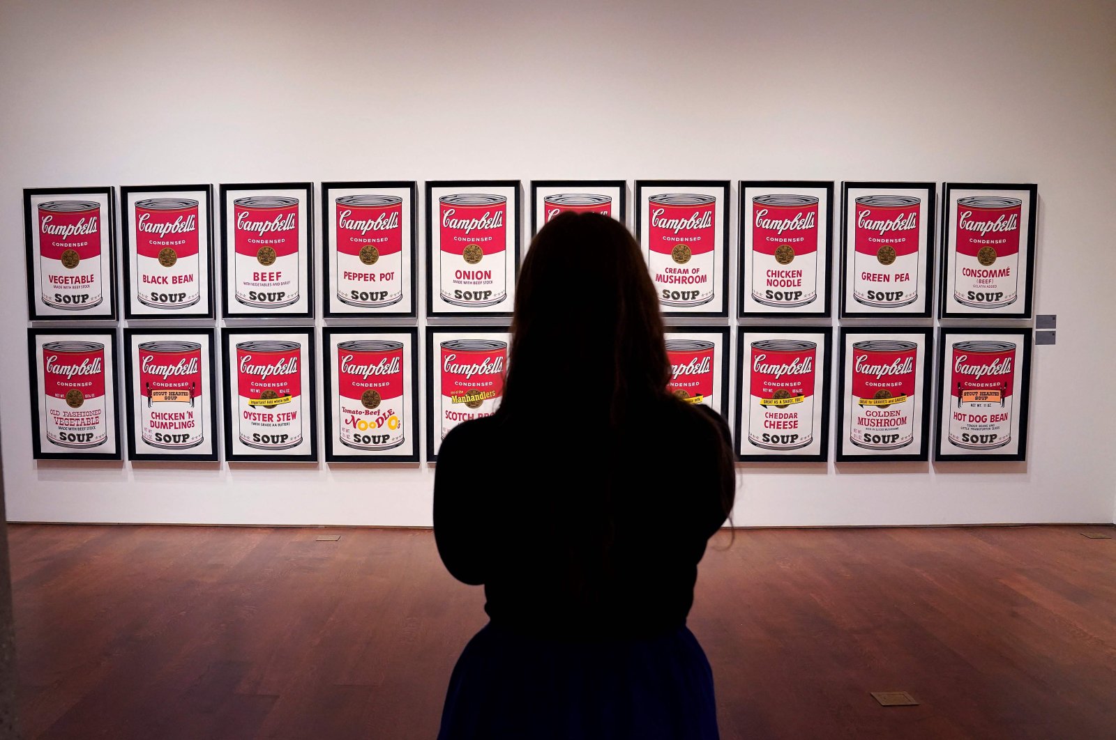 A woman looks at Andy Warhol’s “Campbell&#039;s Soup 1&amp;2” at Sotheby’s New York, U.S., Oct. 25, 2022. (AFP Photo)