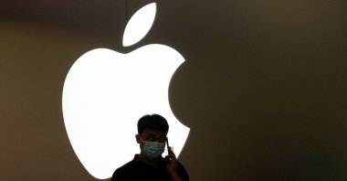 A man talks on a phone in front of an Apple logo outside the Apple store following the COVID-19 outbreak in Shanghai, China, Nov. 7, 2022. (Reuters Photo)