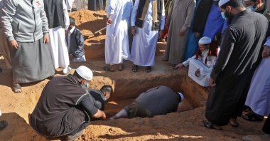 Libyan mourners bury a body unearthed from a mass grave, in a cemetery in the city of Tarhuna, Libya, Nov. 13, 2020. (AFP Photo)