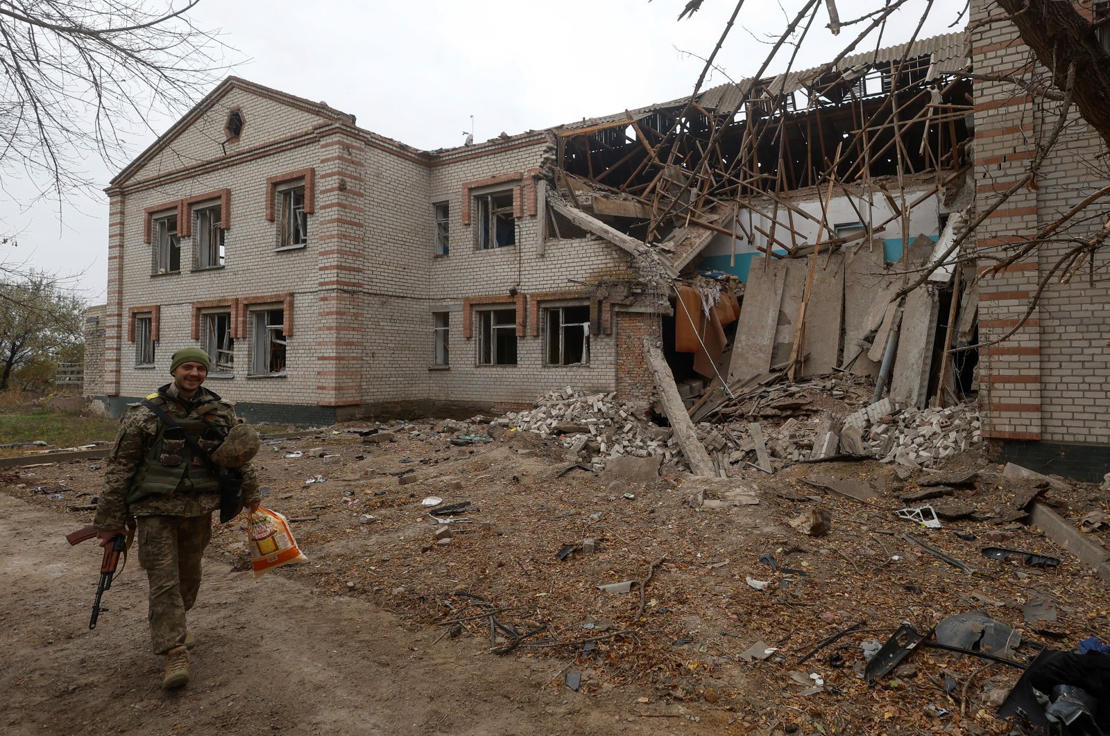 A Ukrainian serviceman walks past a building of a kindergarten damaged during a Russian missile attack in the village of Novooleksandrivka, Kherson, Ukraine, Nov. 9, 2022. (Reuters Photo)