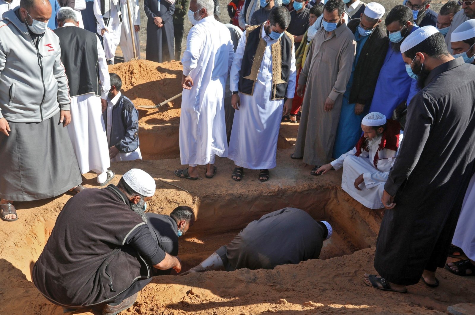 Libyan mourners bury a body unearthed from a mass grave, in a cemetery in the city of Tarhuna, Libya, Nov. 13, 2020. (AFP Photo)