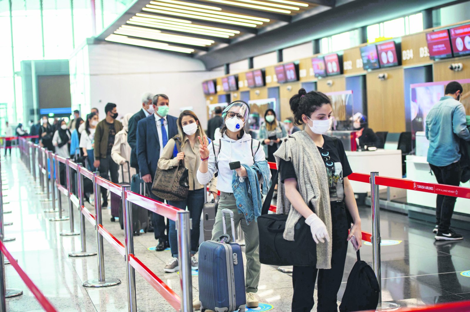Travelers at the Istanbul Airport wearing protective face masks queue as an employee serves a passenger, Istanbul, Türkiye, June 1, 2020. (AFP Photo)