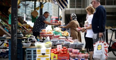People buy products from a fruit and vegetable market stall in central London, U.K., Aug.19, 2022. (Reuters Photo)