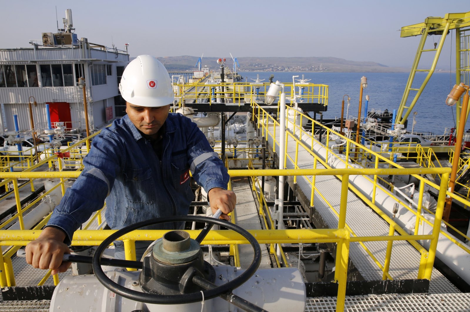 A worker checks the valve gears of pipes linked to oil tanks at Türkiye&#039;s Mediterranean port of Ceyhan. (Reuters Photo)