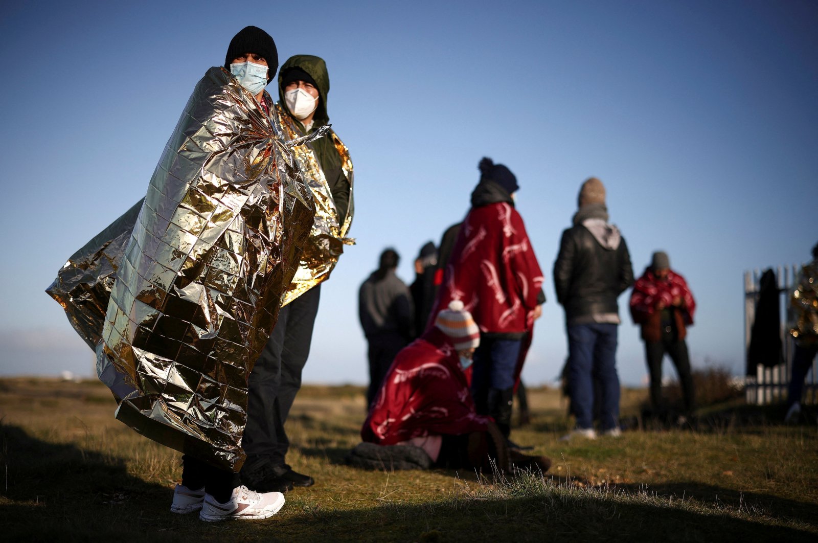 Migrants stand on the beach after crossing the English Channel in an inflatable dinghy, in Dungeness, Britain, Jan. 18, 2022. (Reuters File Photo)