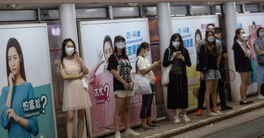 People wear masks at a tramway stop in Wanchai district, Hong Kong, China, Oct. 14, 2022. (EPA Photo)