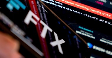 This photo illustration shows a message reading “We strongly advise against depositing” on the website of cryptocurrency FTX, displayed near its logo, in Washington, U.S., Nov. 13, 2022. (AFP Photo)