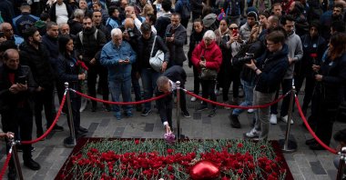 A mourner lays flowers as people grieve the victims of November 13 terror attack at Istiklal Street, in Istanbul, Türkiye, Nov. 14, 2022. (AFP Photo) 