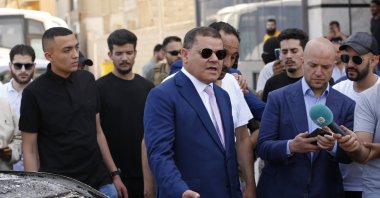 Abdul Hamid Dbeibah, one of Libya’s two rival prime ministers (C) speaks to residents as he visits a Tripoli neighborhood after competing militias fought there, in Tripoli, Libya, May 17, 2022. (AP File Photo)