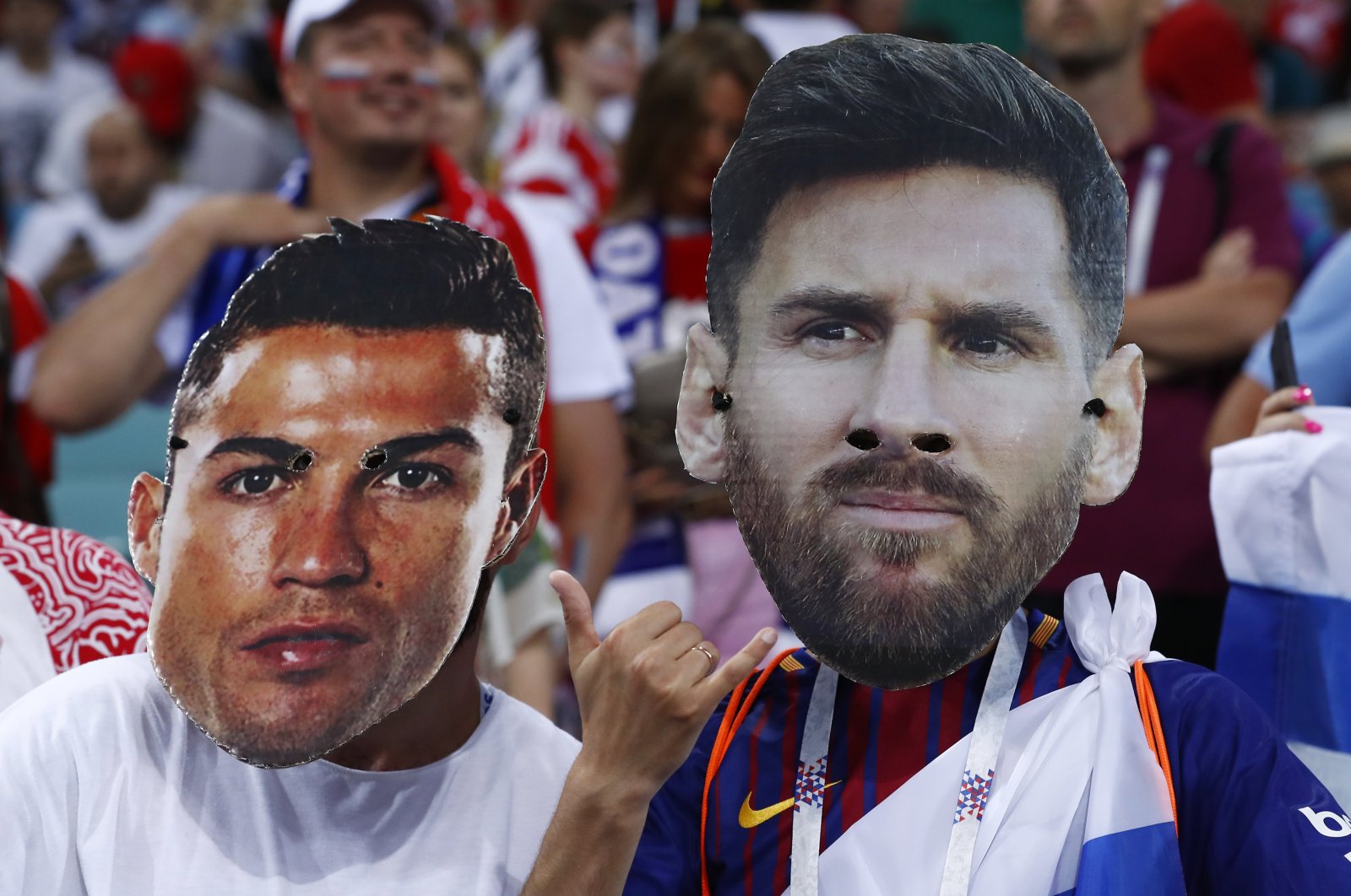 Fans wear masks with the face of Cristiano Ronaldo (L) and Lionel Messi at the 2018 World Cup, Sochi, Russia, July 7, 2018. (AP Photo)
