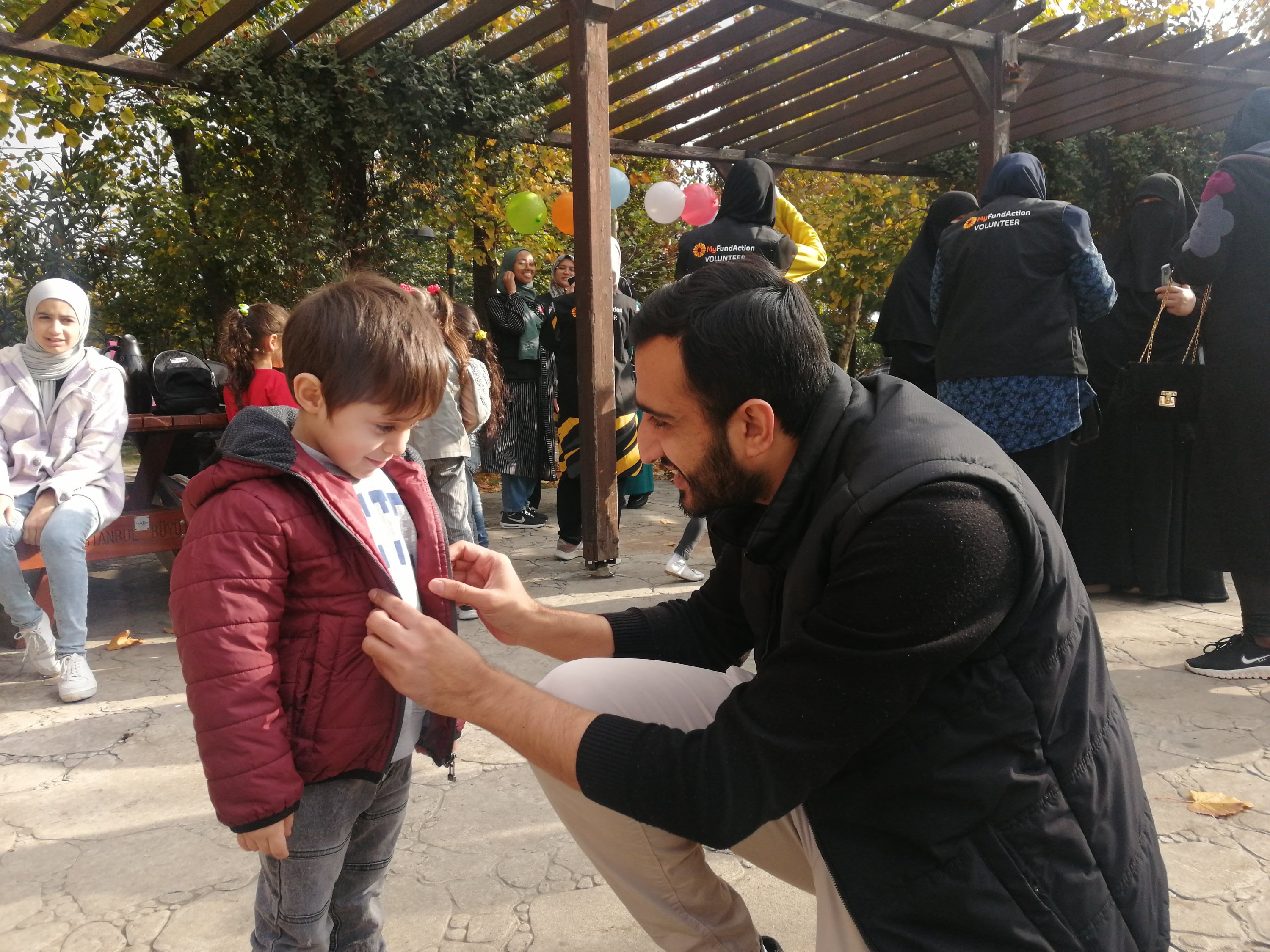 Seorang relawan membantu salah satu anak dengan mantel mereka, Istanbul, Türkiye, 13 November 2022. (Foto oleh Sisa Bodani)