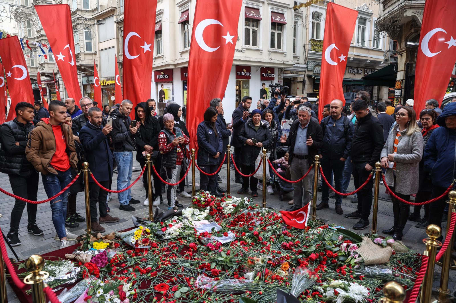 People gather at the scene of the attack, filled with flowers left by mourners, on Istiklal Street, in Istanbul, Türkiye, Nov. 15, 2022. (AA Photo)