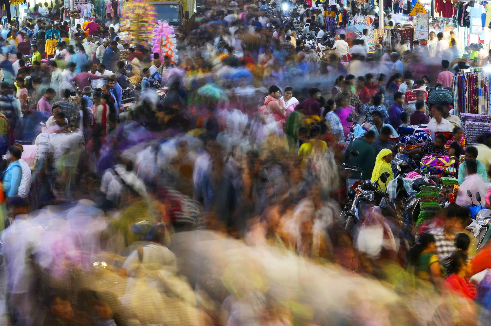 People move through a market in Mumbai, India, Nov. 12, 2022. (AP Photo)