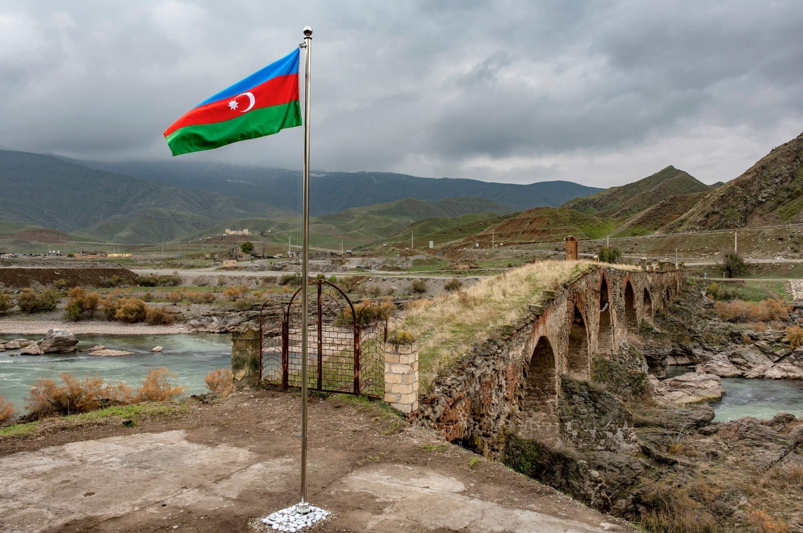 An Azerbaijani national flag flies next to the medieval Khudaferin bridge in Jebrayil district at the country&#039;s border with Iran, Azerbaijan, Dec. 9, 2020. (AFP Photo)