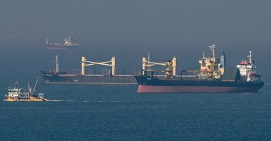 The cargo ship Super Bayern (C), carrying Ukrainian grain, is seen behind a fishing trawler (L) at the entrance of the Bosporus, in the Black Sea off the coast off Kumköy, north of Istanbul, Türkiye, Nov. 2, 2022. (AFP Photo)