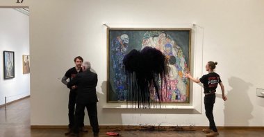 The picture shows a climate activist of the "Last Generation" group being overpowered whereas another one has glued himself to the painting "Death and Life" by Austrian artist Gustav Klimt after pouring black liquid over the artwork at the Leopold Museum in Vienna, Austria, Nov. 15, 2022. (AFP Photo)