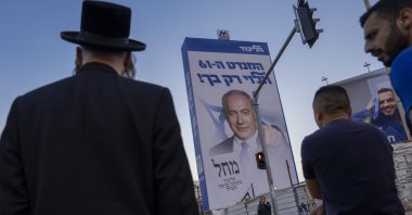 People walk past an election campaign billboard showing Benjamin Netanyahu, Bnei Brak, Israel, Oct. 25, 2022. (AP Photo)