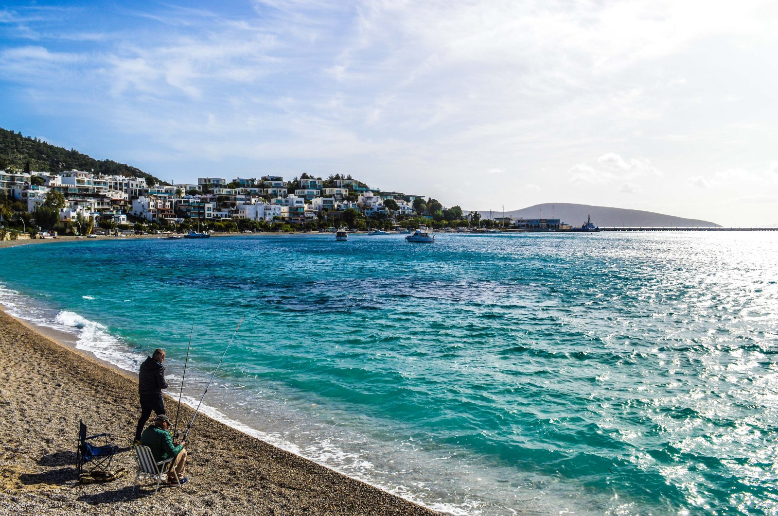Two fishermen try to catch fish from a beach, in Bodrum, Türkiye, Feb. 11, 2021. (Getty Images Photo)