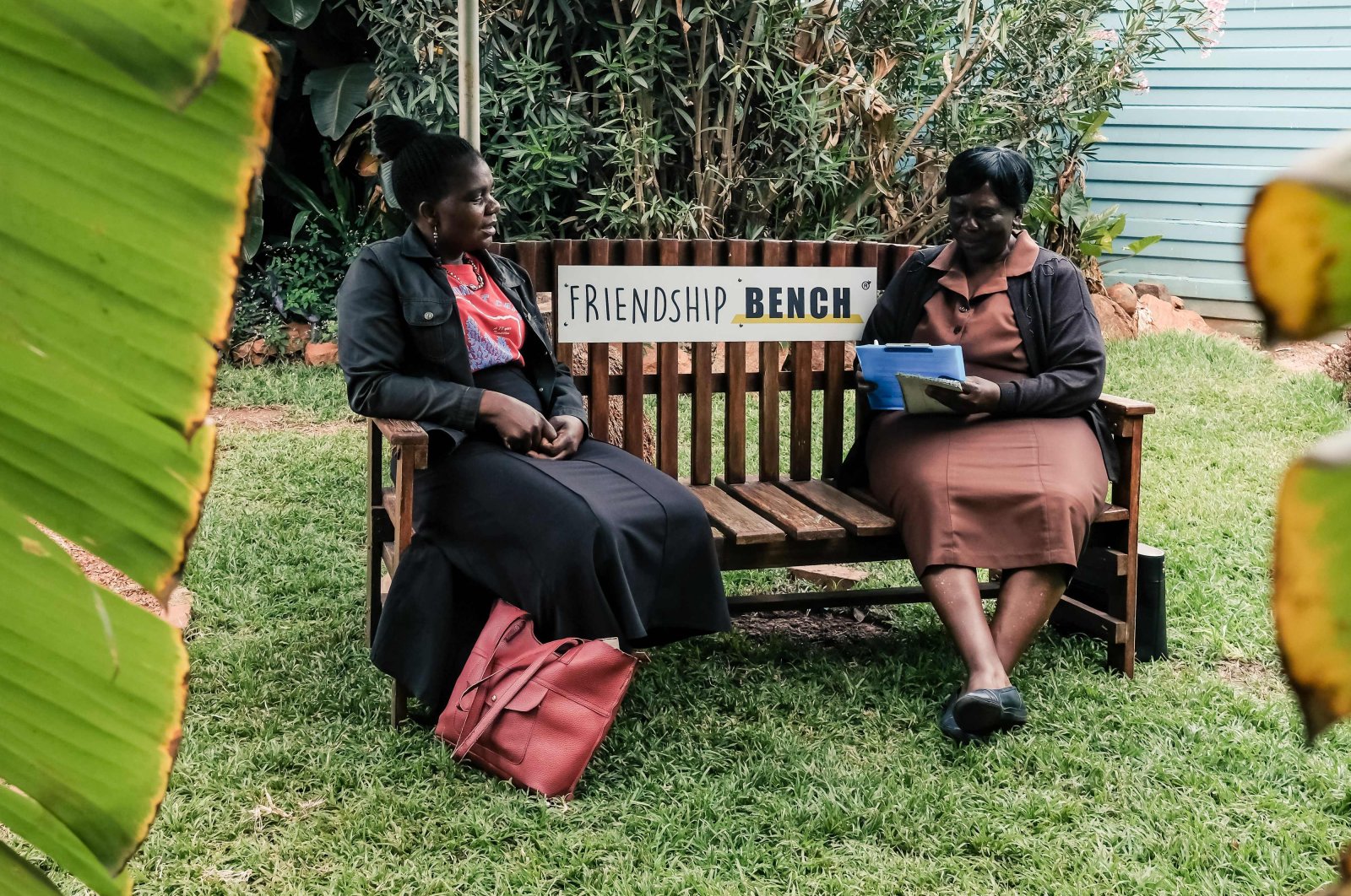 Counsellor &quot;Gogo&quot; Shery Ziwakayi (R) sits on a bench in conversation with a client during a private counselling session at the Friendship Bench in Harare, Zimbabwe, Nov. 2, 2022. (AFP Photo)