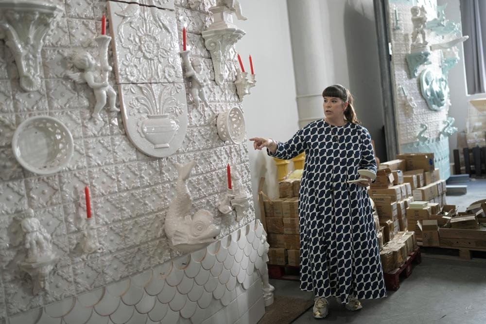 Portuguese artist Joana Vasconcelos points at a full size work model of a section of her 12 meters high and 15 meters wide ceramic wedding cake, at her studio in Lisbon, Portugal, Nov. 11, 2022. (AP Photo)
