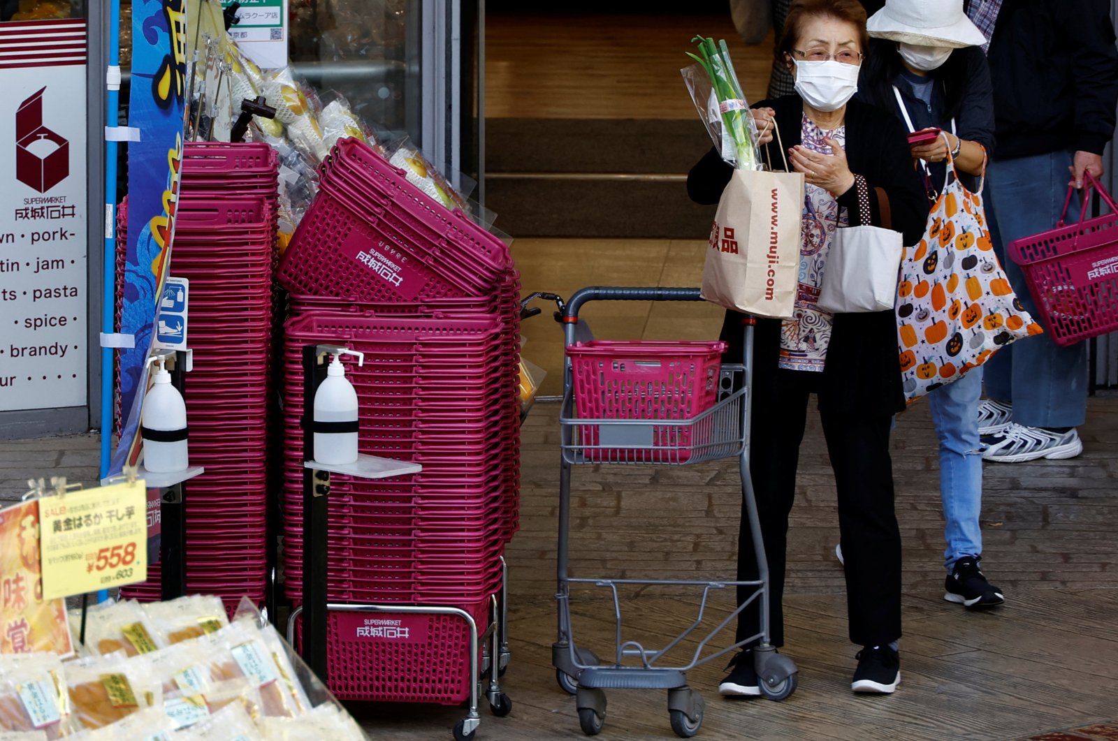 Customers carrying shopping bags are seen outside a supermarket in Tokyo, Japan, Oct., 21, 2022. (Reuters Photo)
