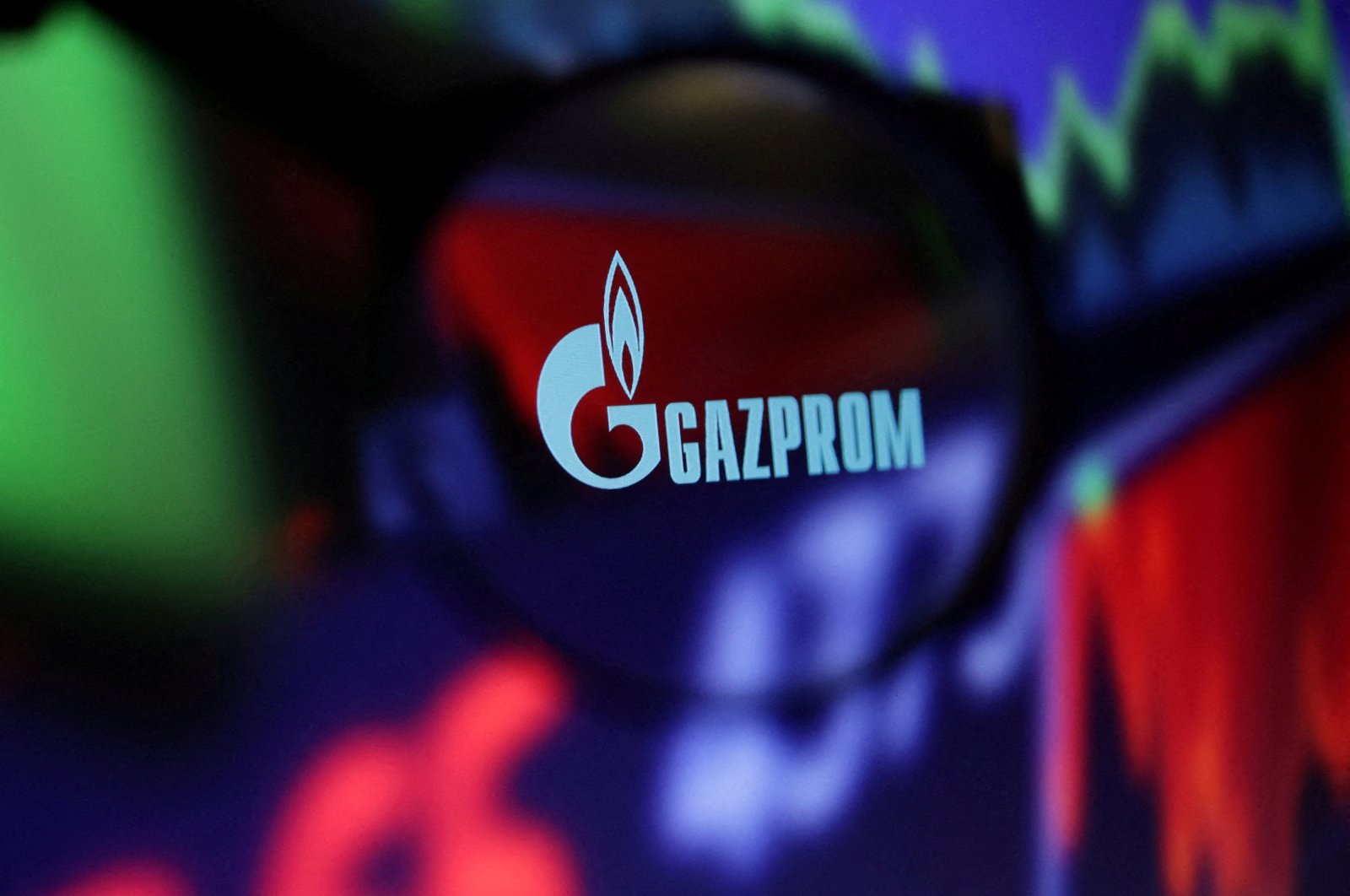 The Gazprom logo and stock graph are seen through a magnifier displayed in this illustration, Sept. 4, 2022. (Reuters File Photo)