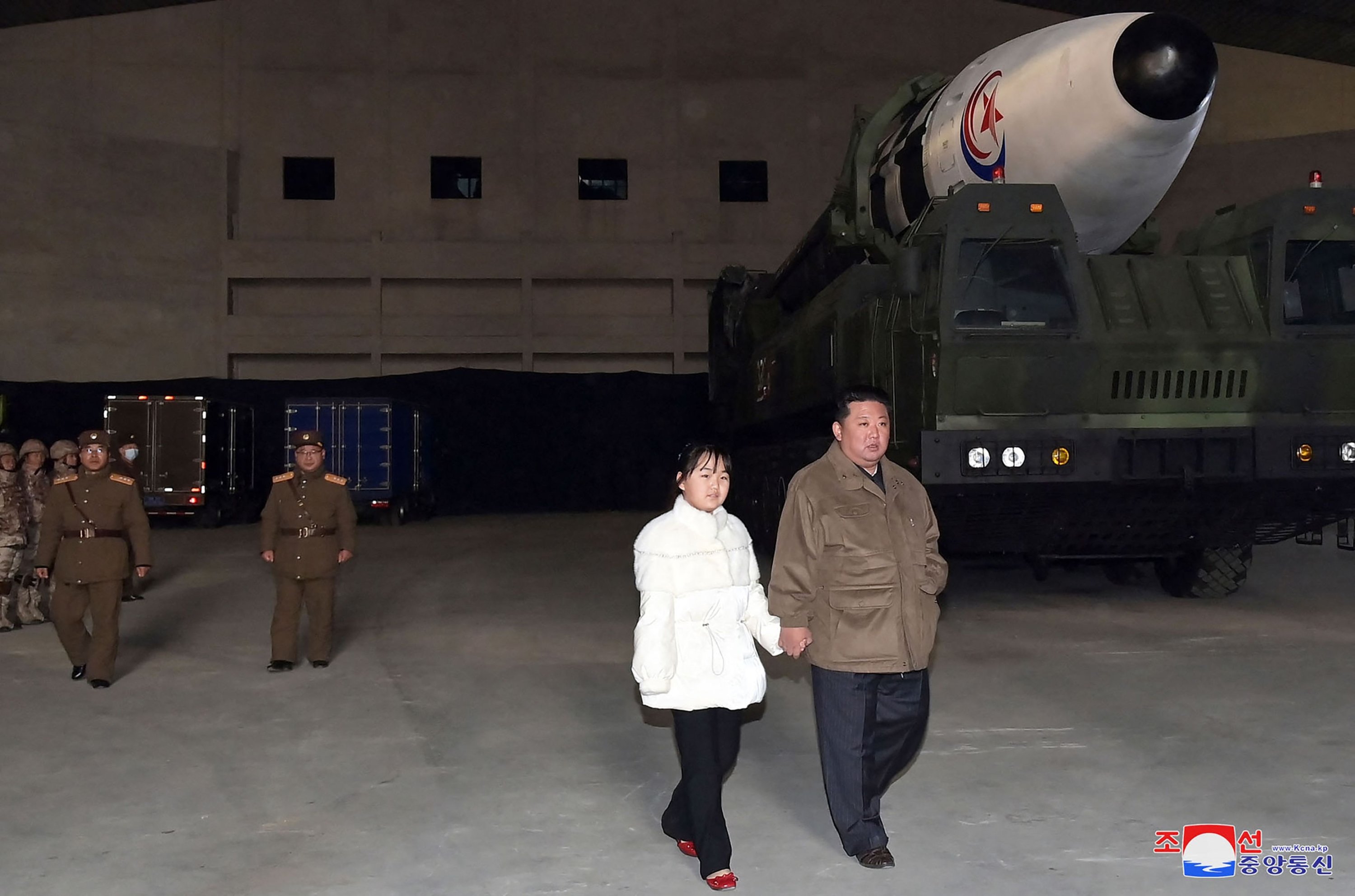 Gambar ini diambil pada 18 November 2022, dan dirilis oleh Kantor Berita Pusat Korea (KCNA) resmi Korea Utara pada 19 November 2022, menunjukkan pemimpin Korea Utara Kim Jong Un berjalan dengan putrinya saat dia memeriksa rudal balistik antarbenua baru ( ICBM) 'Hwasong Gun 17,' menjelang peluncurannya di Bandara Internasional Pyongyang.  (Foto oleh KCNA VIA KNS/AFP)