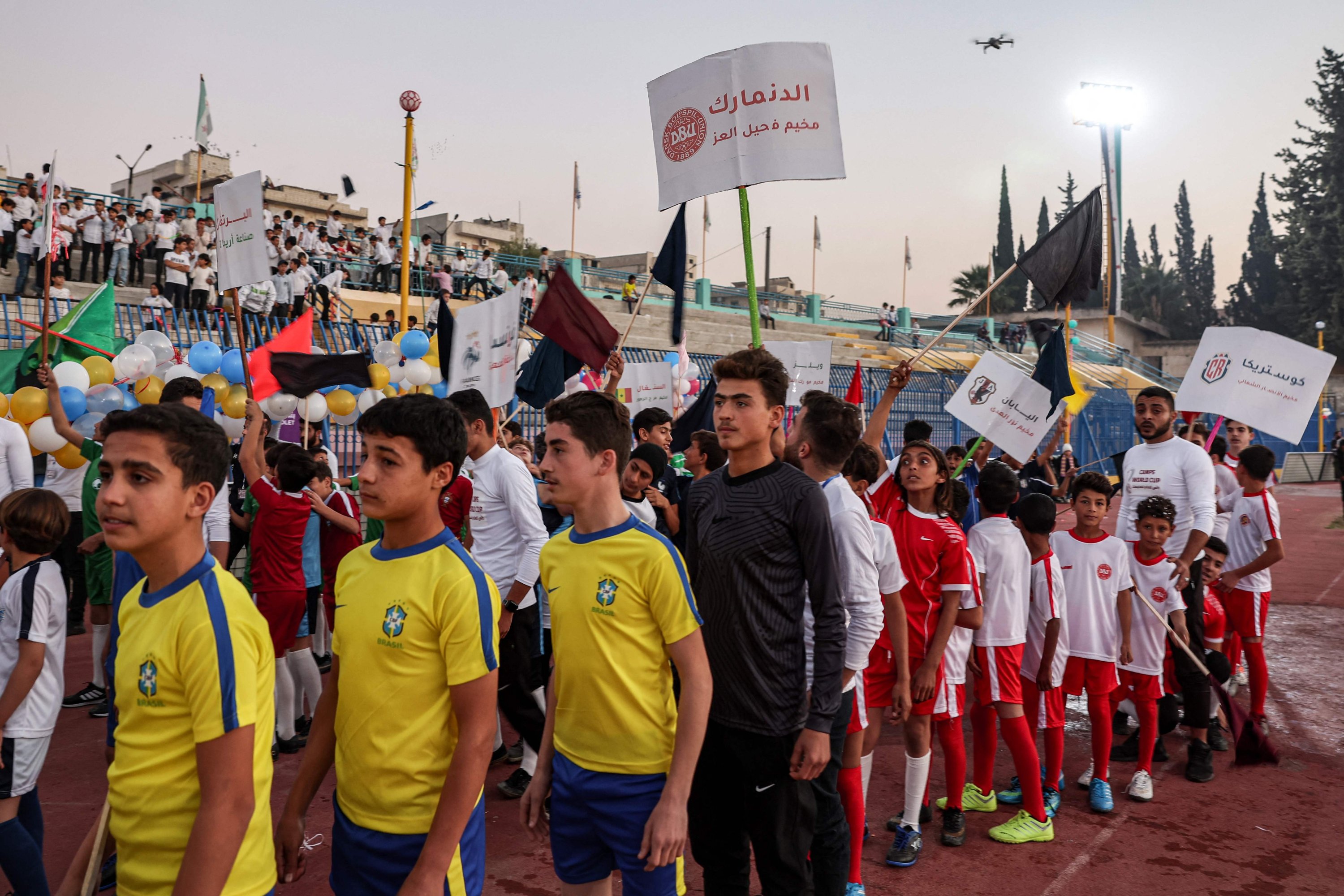 Anak-anak yang mengenakan seragam tim sepak bola nasional yang bermain di Piala Dunia FIFA Qatar 2022 berbaris saat upacara pembukaan Piala Dunia FIFA 