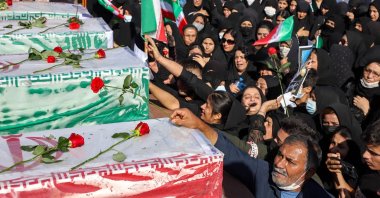 Iranians mourn in front of the coffins of people killed in a shooting attack, during their funeral in the city of Izeh in Iran's Khuzestan province, on Nov. 18, 2022. In some of the worst violence since the protests erupted, assailants on motorbikes shot dead seven people, including a woman and two children aged 9 and 13, at a central market of Izeh on the evening of Nov. 16, 2022, state media said. (AFP Photo)