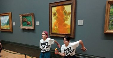 Activists of &quot;Just Stop Oil&quot; glue their hands to the wall after throwing soup at a van Gogh&#039;s painting &quot;Sunflowers&quot; at the National Gallery in London, Britain, Oct. 14, 2022. (Reuters Photo)