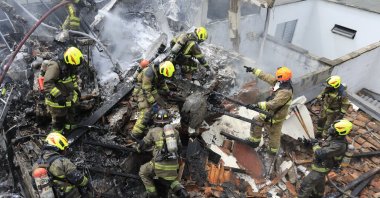 Firefighters work at the crash site of a small plane that fell on top of homes in a residential area of Medellin, Colombia, Monday, Nov. 21, 2022. (AP Photo)