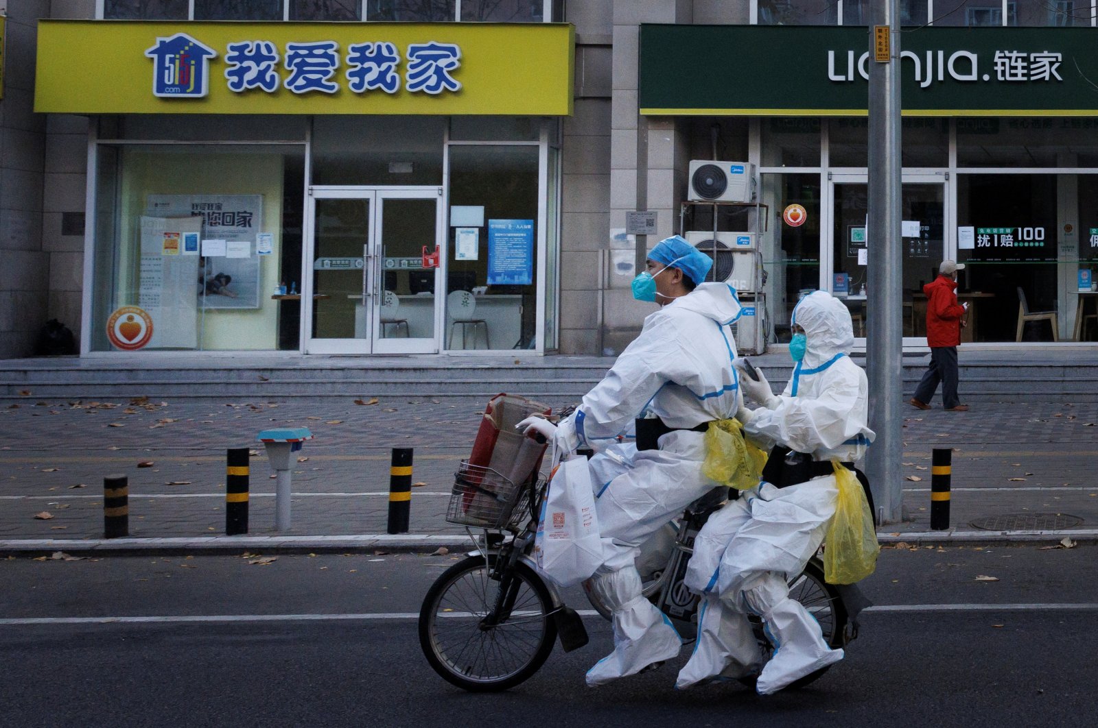 Pandemic prevention workers in protective suits ride an electric bike in Beijing, China, Nov. 21, 2022. (Reuters Photo)