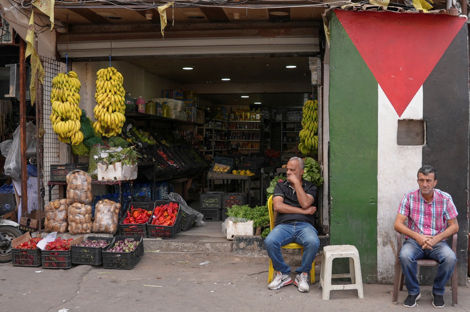 Men sit outside a grocery store at Burj al-Barajneh Palestinian refugee camp in Beirut, Lebanon, Nov. 2, 2022. (Reuters Photo)