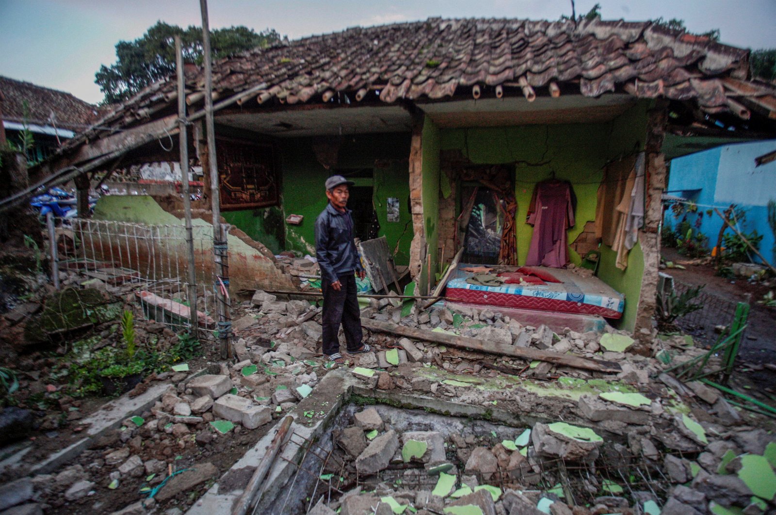 A local stands in front of his house, damaged after earthquake hit in Cianjur, West Java province, Indonesia, Nov. 21, 2022. (Antara Foto/Yulius Satria Wijaya/ via Reuters) 