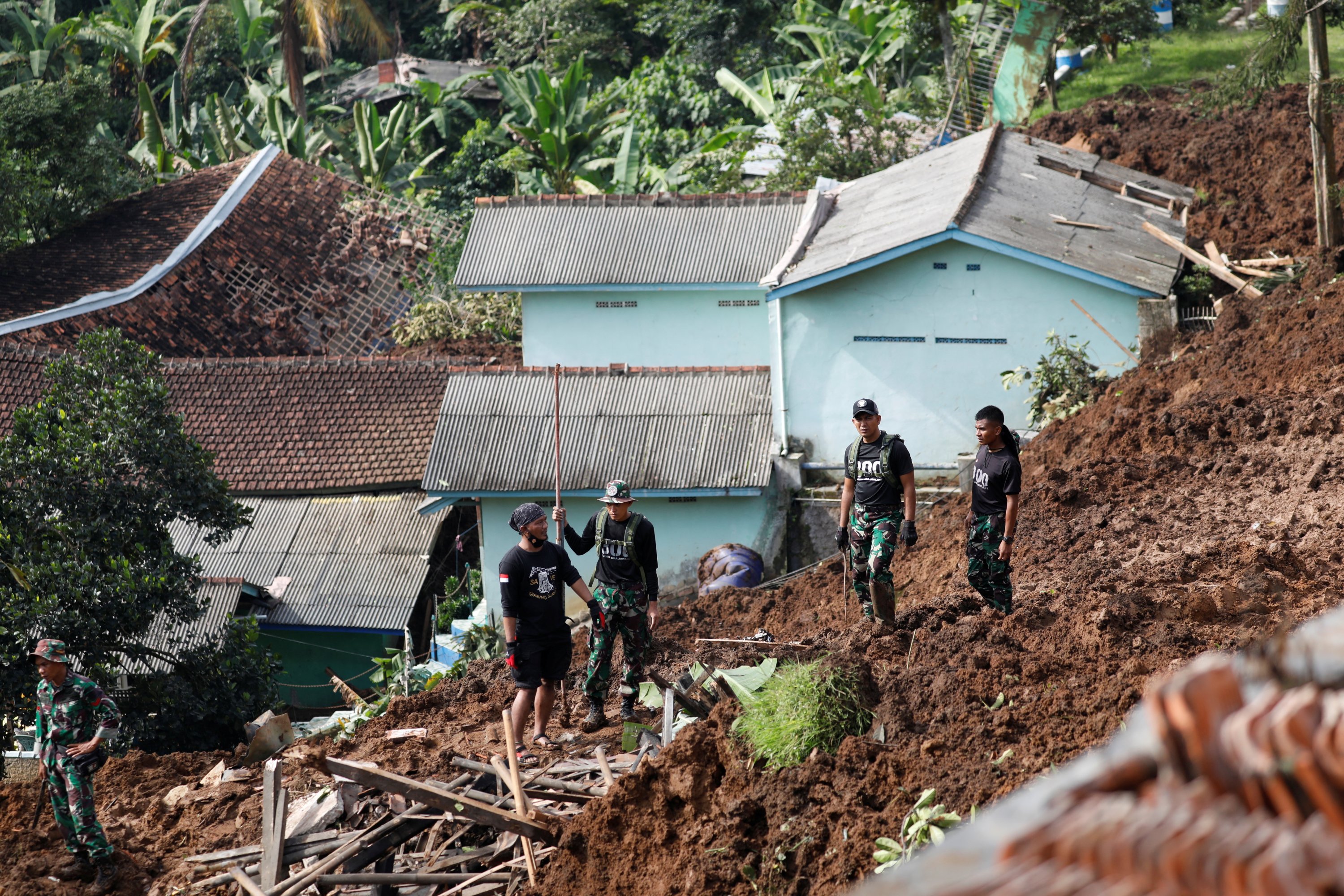 Perwira TNI berdiri saat mengevakuasi warga dari lokasi longsor akibat gempa di Cugenang, Cianjur, Indonesia, 22 November 2022. (Foto Reuters)