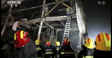This screengrab shows rescuers using responding to a fire at an industrial wholesaler in Henan, China, Nov. 21, 2022. (AP Photo)