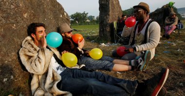 Festival goers inhale laughing gas at sunrise at the stone circle on the second day of the Glastonbury music festival at Worthy Farm in Somerset, U.K., June 27, 2013. (Reuters Photo)
