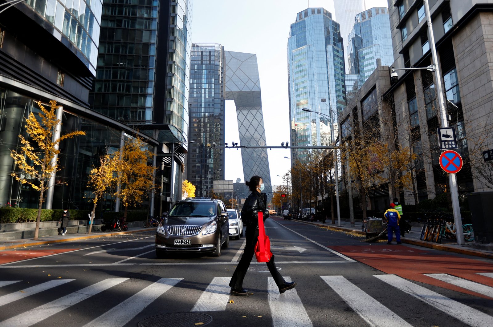 A woman walks across the street during morning rush hour, following a COVID-19 outbreak in the Central Business District (CBD), Beijing, China, Nov. 21, 2022. (Reuters Photo)
