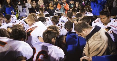 Bremerton High School assistant football coach Joe Kennedy, (center in blue), kneels and prays after his team lost to Centralia in Bremerton, Wash., Oct. 16, 2015. ( AP Photo)