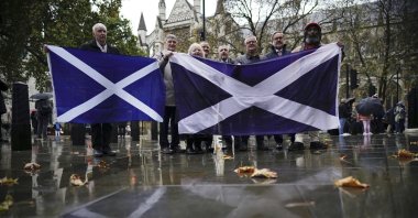 People hold a Scottish flag as they stand outside Britain's Supreme Court, London, U.K., Nov. 11, 2022. (AP Photo)