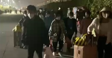 People with suitcases and bags are seen leaving from a Foxconn compound in Zhengzhou in central China's Henan province on Oct. 29, 2022.  (AP photo)