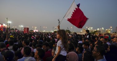 A girl waves a Qatari flag at a fan zone during the opening ceremony for the World Cup, prior to the group A soccer match between Qatar and Ecuador, in Doha, Qatar, Nov. 20, 2022. (AP Photo)