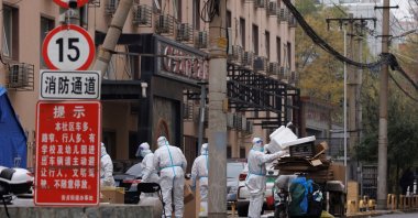Pandemic prevention workers in protective suits collect trash in a locked-down residential compound as outbreaks of COVID-19 continue in Beijing, China, Nov. 18, 2022. (Reuters Photo)