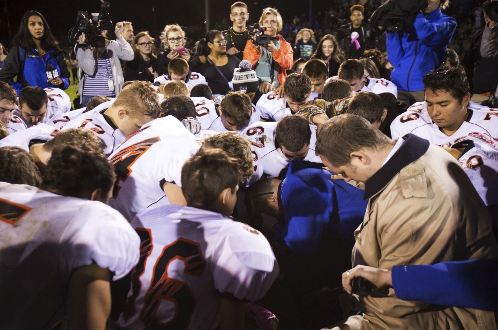 Bremerton High School assistant football coach Joe Kennedy, (center in blue), kneels and prays after his team lost to Centralia in Bremerton, Wash., Oct. 16, 2015. ( AP Photo)